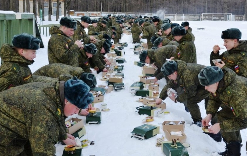 Солдаты на природе едят продукты из сухпайка